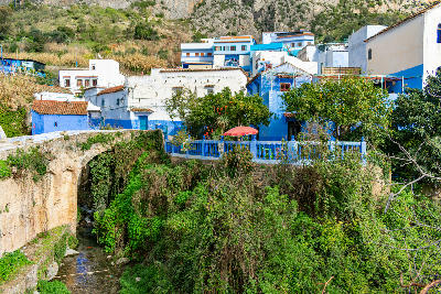 Blue and white buildings above the Ras El Maa stream in Chefchaouen, Morocco