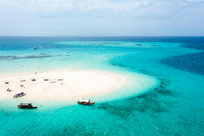 Aerial view of a pristine white sandbank surrounded by turquoise waters near Mnemba Atoll, Zanzibar, Tanzania.