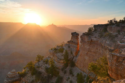 Sunrise at Yaki Point on the Grand Canyon South Rim with warm light illuminating cliff edges and layered canyon depth