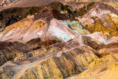 Colorful mineral hills at Artist’s Palette, Death Valley National Park, California, showing pastel green, pink, yellow and purple slopes in desert badlands.