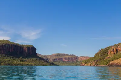 Broad turquoise waters of the Hunter River surrounded by rugged sandstone escarpments and remote Kimberley wilderness.
