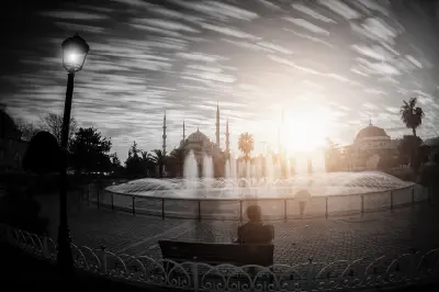 Sultanahmet Square fountain at sunset with the Blue Mosque silhouetted in the background, Istanbul, Turkey.