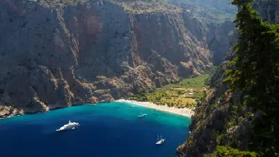 Butterfly Valley's beach and turquoise bay surrounded by towering cliffs near Ölüdeniz, Türkiye.