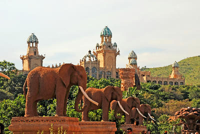 Large elephant statues lining the Bridge of Time with The Palace of the Lost City in the background at Sun City Resort, North West Province, South Africa.