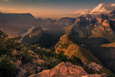 The Three Rondavels rock formations above Blyde River Canyon in Mpumalanga, South Africa, illuminated by warm sunset light.