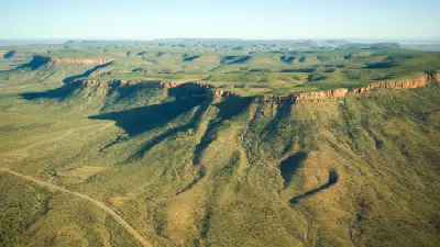 Aerial view of the Cockburn Range showing long red escarpments, deeply eroded slopes and vast rugged Kimberley wilderness.