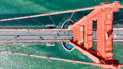 Aerial top-down view of the Golden Gate Bridge showing roadway traffic and suspension cables over the water