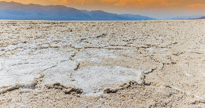 Badwater Basin salt flats with cracked salt polygons and Panamint Mountains in Death Valley National Park, California