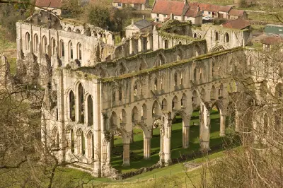 Elevated view of the ruined Gothic church at Rievaulx Abbey, showing rows of tall stone arches and surviving medieval walls in North Yorkshire.