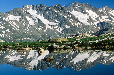 Alpine lake reflecting snow-covered peaks in Vanoise National Park, French Alps
