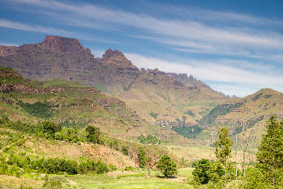 View of Champagne Castle and the surrounding Drakensberg peaks above green foothills and valleys in the Central Drakensberg, KwaZulu-Natal, South Africa.