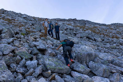 hikers ascending rocky slope Grytetippen Senja Norway mountain trail terrain