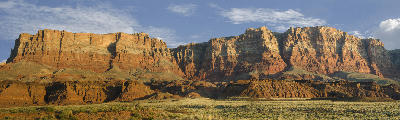 Layered red sandstone cliffs of Vermilion Cliffs above desert landscape in northern Arizona