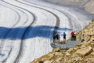 Visitors on the Eggishorn viewing platform overlooking the Aletsch Glacier in the Swiss Alps.