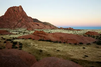 Granite peaks and rounded rock formations rising from desert plains at Spitzkoppe in Namibia.