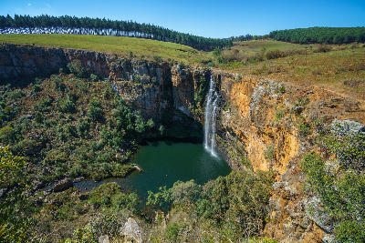 Berlin Falls dropping into a deep plunge pool below orange cliffs on the Panorama Route near Graskop, Mpumalanga, South Africa.