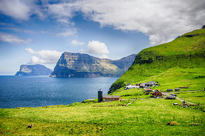 Green cliffs and coastal farmland on Kalsoy in the Faroe Islands near the trail to Kallur Lighthouse.