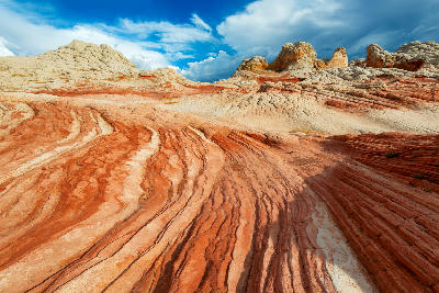 White Pocket sandstone patterns with red and white layered rock formations under blue sky Arizona