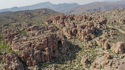 Aerial view of rugged sandstone cliffs, rock formations, and semi-arid valleys in the Cederberg Wilderness Area, Western Cape, South Africa.