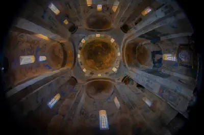 Interior of Holy Cross Church on Akdamar Island, showing its central dome, stone arches and historic Armenian frescoes.