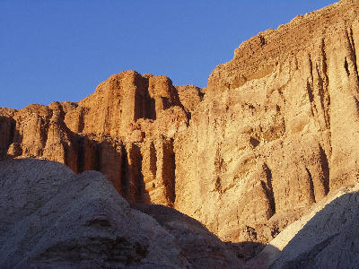 Red Cathedral cliffs Golden Canyon Death Valley with sunlit vertical rock walls below Zabriskie Point