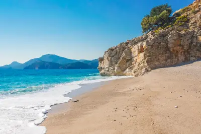 Sandy beach and rocky coastline at Kıdrak Bay near Ölüdeniz and Fethiye, Türkiye.