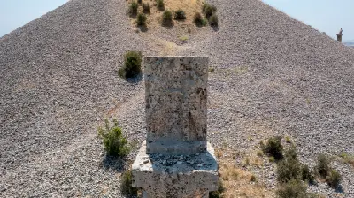 Ancient stone funerary monument in front of the gravel burial mound at Karakuş Tumulus in Adıyaman, Turkey.
