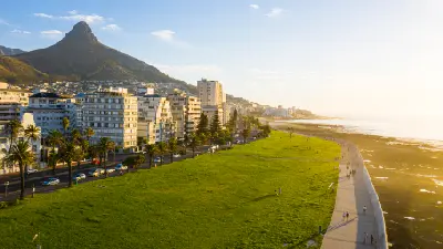 Aerial view of the Sea Point Promenade with Lion’s Head rising behind the Sea Point coastline in Cape Town, South Africa.
