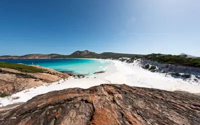 White sand and turquoise water at Hellfire Bay, surrounded by granite outcrops in Cape Le Grand National Park, Western Australia.