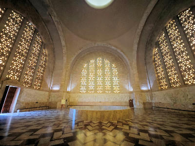 Interior of the Hall of Heroes in the Voortrekker Monument showing marble floors, arched windows and the oculus above the Cenotaph.