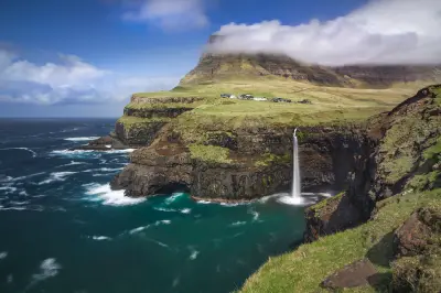 Múlafossur Waterfall falling into the Atlantic Ocean beneath Gásadalur village on Vágar Island, Faroe Islands.