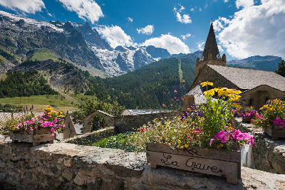 La Grave alpine village with church and La Meije glacier peaks in the French Alps