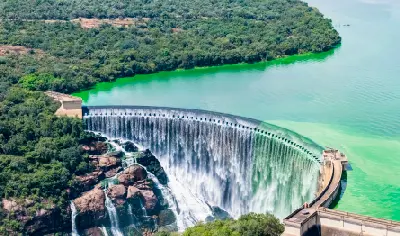 Aerial view of the Roodeplaat Dam spillway and reservoir surrounded by bushveld vegetation near Pretoria in Gauteng, South Africa.