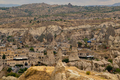 Panoramic view of Göreme, Cappadocia, featuring cave hotels, fairy chimneys, rock-carved homes and the surrounding volcanic landscape.