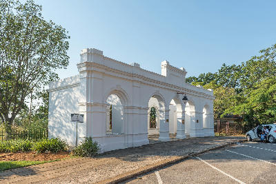 Historic illustration of Barberton during the Transvaal gold rush, showing prospectors, wagons and mining settlement buildings in the late 1800s.