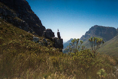Silhouette of a hiker standing on rocky cliffs above Jonkershoek Valley in Jonkershoek Nature Reserve near Stellenbosch, South Africa.