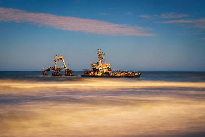 Long-exposure view of the abandoned Zeila shipwreck off Namibia’s Skeleton Coast with waves blurred around the rusting vessel.