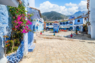 Blue-painted plaza and traditional Moroccan architecture in Chefchaouen, surrounded by the Rif Mountains in northern Morocco