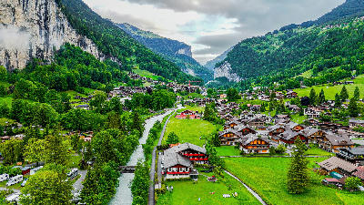 Aerial view of Lauterbrunnen village with wooden chalets along the valley floor and river in the Bernese Oberland, Switzerland.