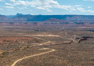 Winding dirt roads crossing a high desert plateau with red rock mesas in Southern Utah near Kanab.