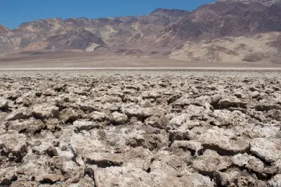 Wide view of Devils Golf Course salt flats in Death Valley National Park California showing rugged broken salt crust and mountain backdrop