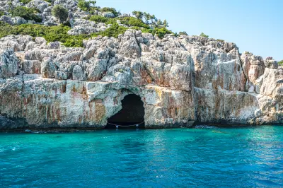 Rocky coastline and sea cave on Kekova Island, Antalya, Turkey, surrounded by clear turquoise Mediterranean water.