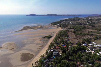 Drone view of the Dzamandzar coastline on Nosy Be island in Madagascar with tidal sandbanks, shallow coastal water, tropical shoreline, and offshore islands.