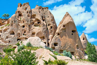 Rock-cut pigeon houses carved into tall fairy chimneys in Pigeon Valley, Cappadocia, Turkey.