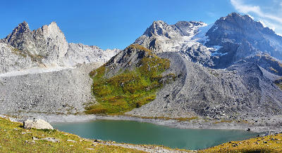 Alpine lake beneath moraine ridges with Grande Casse peak and glacier in the background in Vanoise National Park