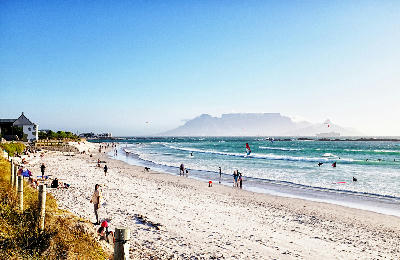 Bloubergstrand beach with kitesurfers and Table Mountain across Table Bay in Cape Town, South Africa.