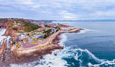 Aerial view of The Point headland and Cape St Blaize Lighthouse overlooking the rocky coastline of Mossel Bay, South Africa.