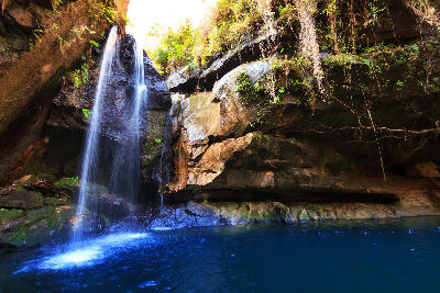 Waterfall cascading into a deep emerald canyon pool in Isalo National Park, Madagascar