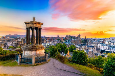 Dugald Stewart Monument on Calton Hill with the skyline of Edinburgh at sunset in Scotland.