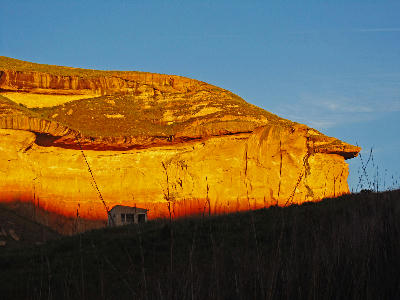 Mushroom Rock illuminated by golden sunset light in Golden Gate Highlands National Park, showing layered sandstone cliffs and dramatic rock formations.